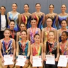 In drei Reihen präsentieren sich die Gymnastinnen mit ihren Medaillen