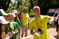 Ein Helfer zeigt Teilnehmenden den Weg.