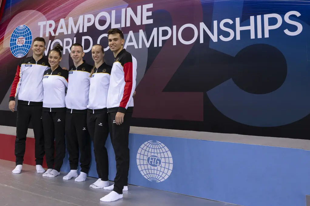 Das Deutsche Team, bestehend aus 5 Personen, stehen vor dem Schriftzug "Trampoline World Championchips)