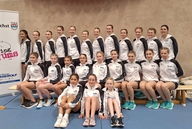 Viele Personen posieren auf einem Podest bei der Siegerehrung.