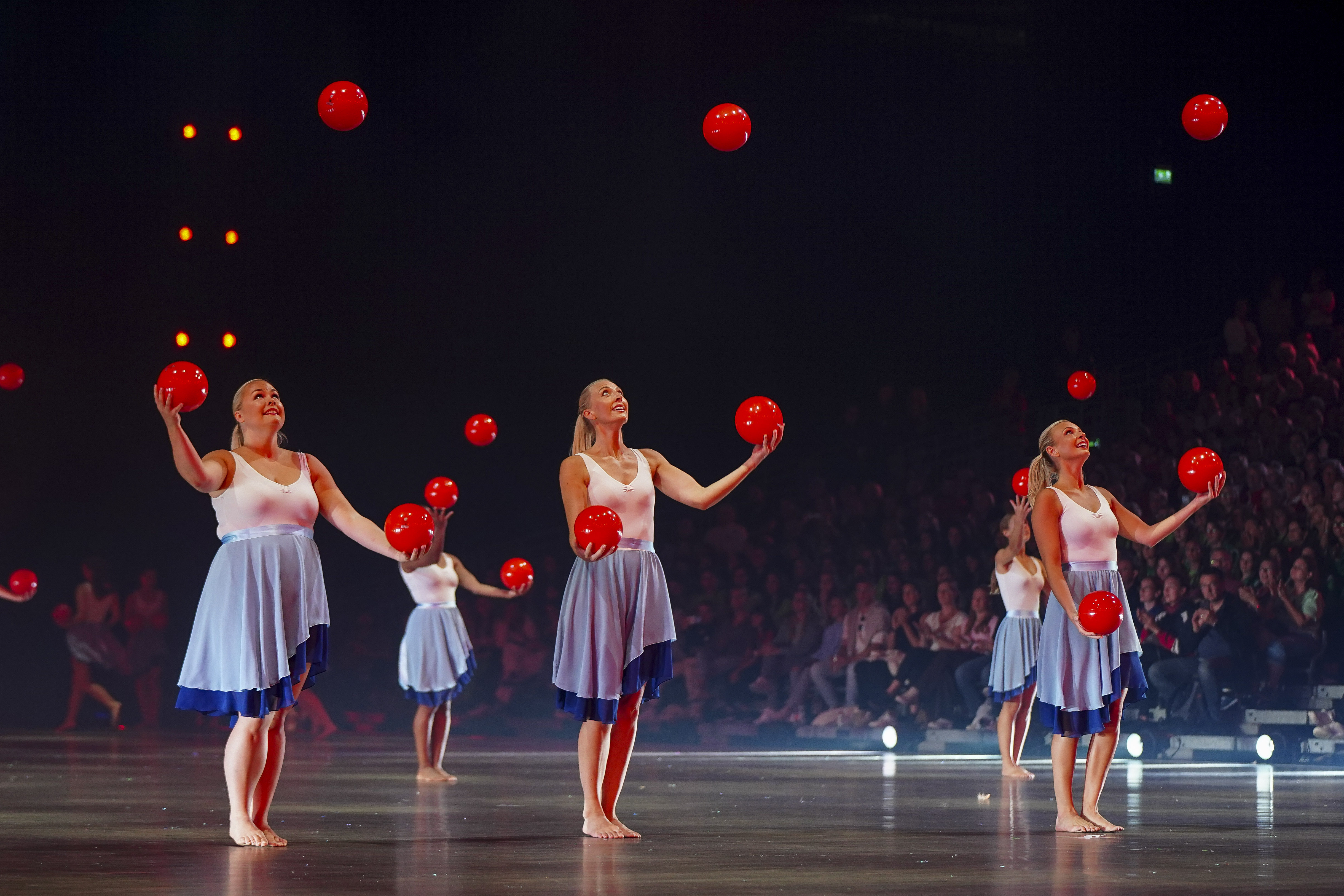 Eine Showgruppe präsentiert eine Vorführung mit Bällen.
