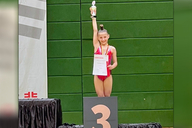Gymnastin streckt Pokal in die Höhe.