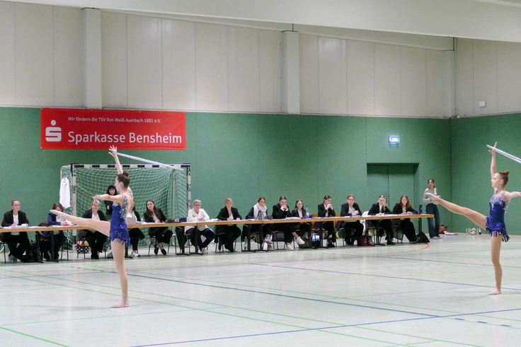 Zwei Gymnastinnen bei ihrer Übung vor dem Kampfgericht