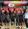 Ein Team freut sich mit Meisterschale über den Sieg.