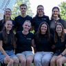 Acht junge Menschen posieren für ein Gruppenfoto