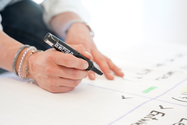 Eine Frau schreibt auf ein Plakat.