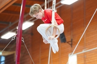 Junger Turner im Stütz an den Ringen