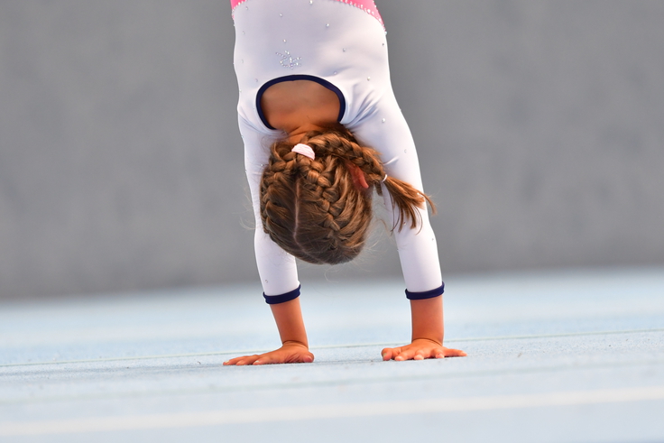 Ein Mädchen macht einen Handstand.