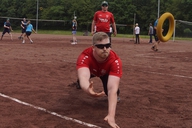 Ein Mann wirft sich auf einem Spielfeld nach einem Tennisring.