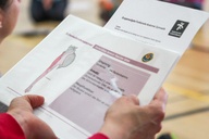 Eine Person liest ein Arbeitsblatt zum Thema Sport.