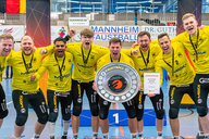 Die Mannschaft steht mit der Siegerschale dicht zusammen und jubelt zur Kamera