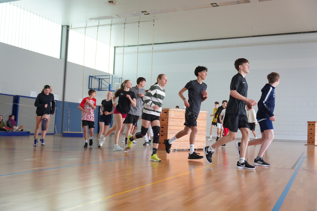 Gruppe von Schüler und Schülerinnen läuft durch die Halle.