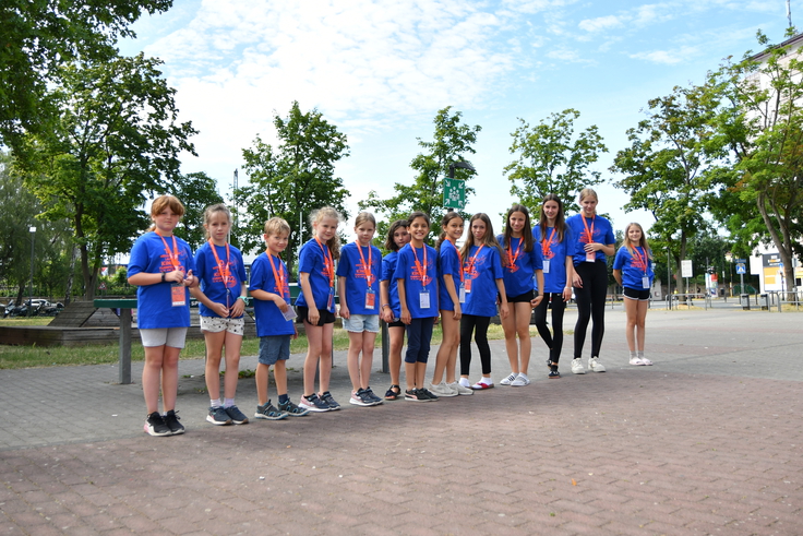 Mehrere Kinden stehen im Turnfest-T-Shirt in einer Reihe aufgestellt auf einem Schulhof.