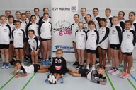 Eine Gruppe Kinder posiert neben einem Roll Up für die Kamera.