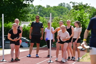 Eine Gruppe aus Frauen laufen gegeneinander in einer Laufstaffel.
