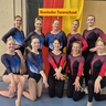 Ein Team aus 10 Turnerinnen posiert für ein Foto.