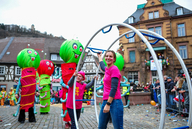 Ein bunter Festumzug mit vielen Teilnehmenden durch eine Altstadt.