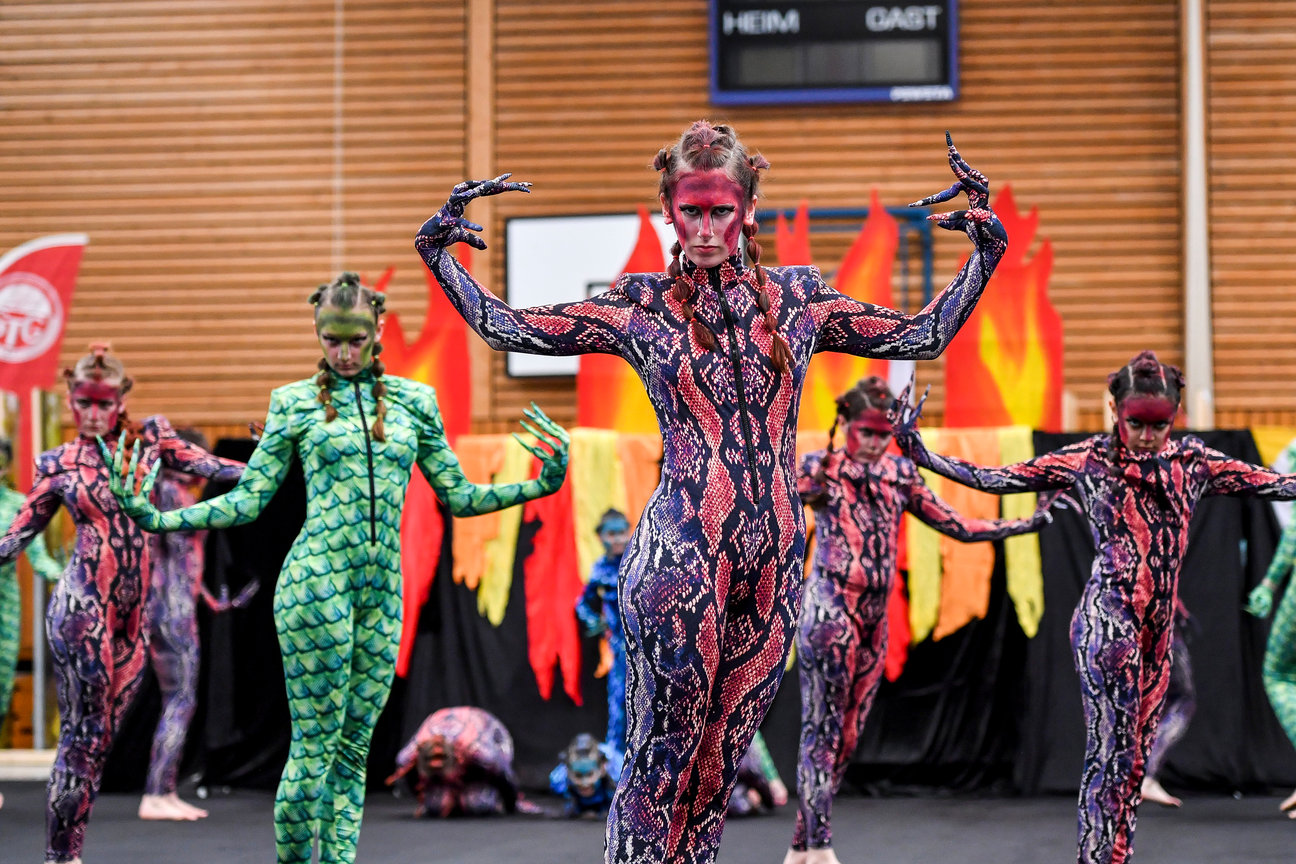 Junge Frauen in Drachen-Kostümen präsentieren eine Show.